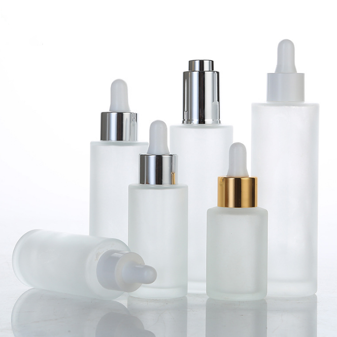 six transparent and various size serum bottles with dropper